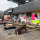 Mourners lie on the ground and pray in front of a memorial to slain rapper Young Dolph at Makeda’s Homemade Cookies in Memphis, Tenn.